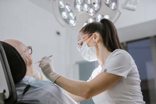 Female dentist working on a patient in a modern dental office with bright lighting.